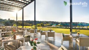 Gran Meliá Iguazú (Argentina) – Luxury With A Front-Row View of Iguazú Falls 🌊✨ 4 Outdoor hotel lobby with tables and chairs, surrounded by lush greenery.