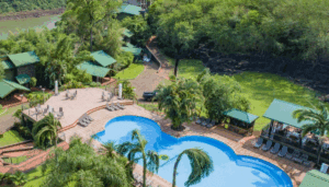 Aerial view of Iguazú Jungle Lodge pool and buildings surrounded by trees.