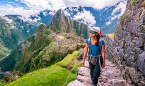 Explore Machu Picchu & The Andes, Peru: Iconic Ruins Amid Breathtaking Mountains 3 Woman wearing a backpack walking up steep stone steps along a valley trail at Machu Picchu, Peru.