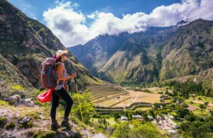 Explore Machu Picchu & The Andes, Peru: Iconic Ruins Amid Breathtaking Mountains 2 Woman wearing a backpack standing in a valley surrounded by steep cliffs and lush vegetation.