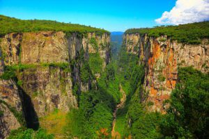 Itaimbezinho Valley in southern Brazil with dramatic steep cliffs surrounded by lush green rainforest vegetation and misty canyon views.