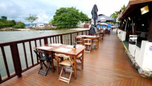 Brazilian street food scene in Florianópolis featuring shrimp, oysters, and hot dogs served at beachside stalls with people enjoying local coastal cuisine.