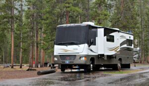 Camper parked at a park with trees and open outdoor space in a natural setting ideal for RV travel and camping