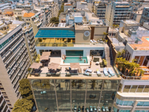 Rio’s Beaches, Coastal Trails & Outdoor Adventures 20 Rooftop hotel pool in Rio de Janeiro surrounded by city buildings, with lounge chairs, outdoor seating, and guests enjoying the terrace.