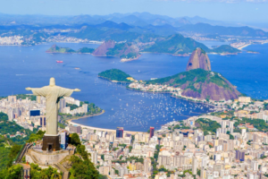 🚠 Sugarloaf Mountain & Urca – Trails, Beaches & Guanabara Bay 9 Panoramic view across Guanabara Bay with Sugarloaf Mountain, Christ the Redeemer, Rio de Janeiro and boats along the Brazilian coastline.