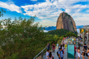 🚠 Sugarloaf Mountain & Urca – Trails, Beaches & Guanabara Bay 15 Visitors exploring Morro da Urca with Sugarloaf Mountain, cable-car lines and tropical scenery in Rio de Janeiro, Brazil.