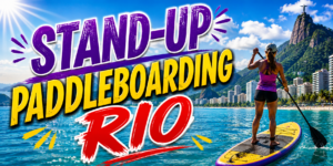 🏄 Rio De Janeiro Beach Adventures – Surfing, Swimming & Water Sports 7 Stand-up paddleboarding in Rio de Janeiro, Brazil, with a paddler on turquoise coastal water surrounded by Rio’s beaches, mountains, and dramatic tropical scenery.