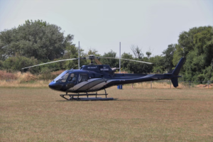 Safari-style helicopter parked on an open field, representing scenic helicopter flights and aerial safari adventures.