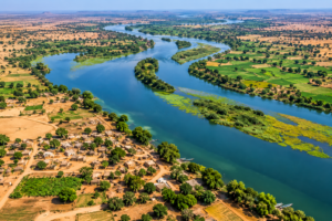 Aerial view of the Senegal River winding through wetlands, farmland, villages and dry Sahel landscapes