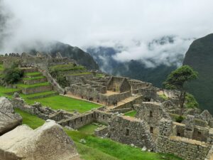 ๐๏ธ Machu Picchu Citadel: Complete Adventure & Visitor Guide 3 Ancient stone buildings, terraces, and stairways at Machu Picchu Citadel in Peru, surrounded by green mountains and low clouds in the Andes.