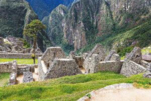 ⛰️ Pisac Ruins, Market & Sacred Valley Adventure 2 Ancient stone ruins and archaeological structures surrounded by dramatic green Andean mountains in Peru.