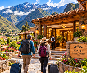 Machu Picchu & Sacred Valley Mountain Adventures: Hiking, Scenery & Outdoor Experiences 12 Travelers with backpacks and luggage walking toward a scenic Sacred Valley hotel surrounded by dramatic Andean mountains in Peru